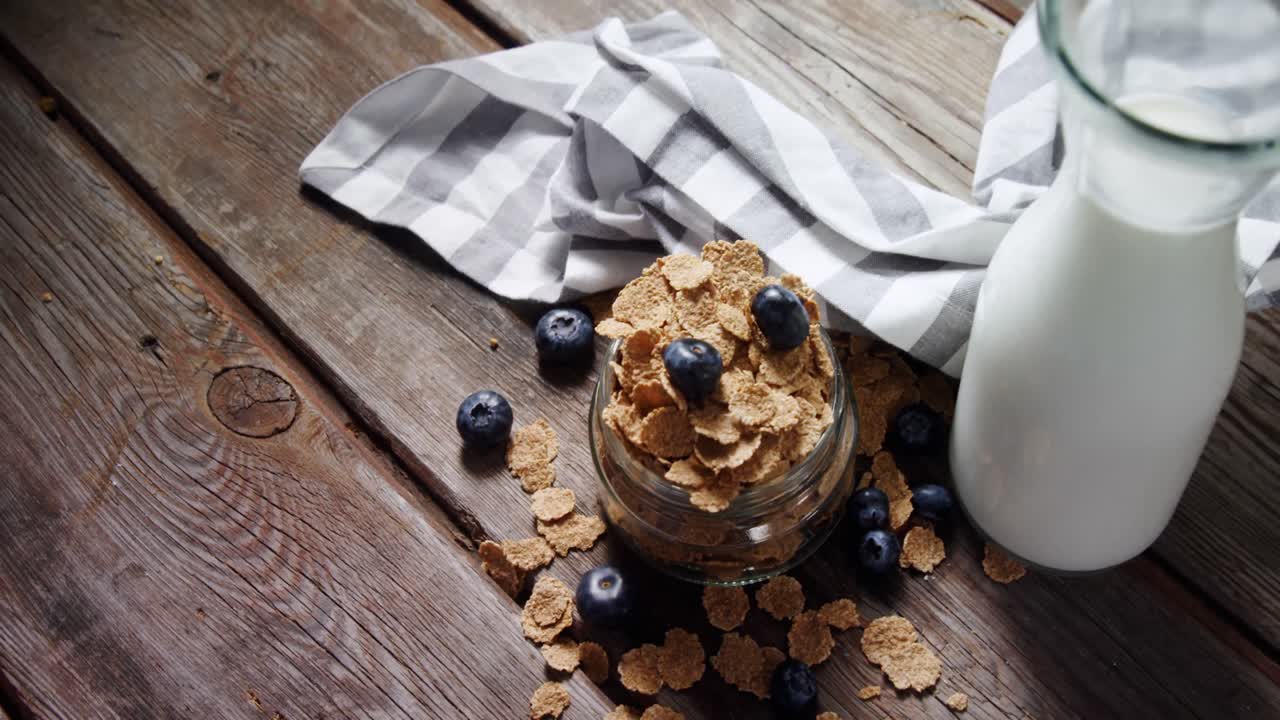 frasco lleno de copos de trigo y arándanos 4k