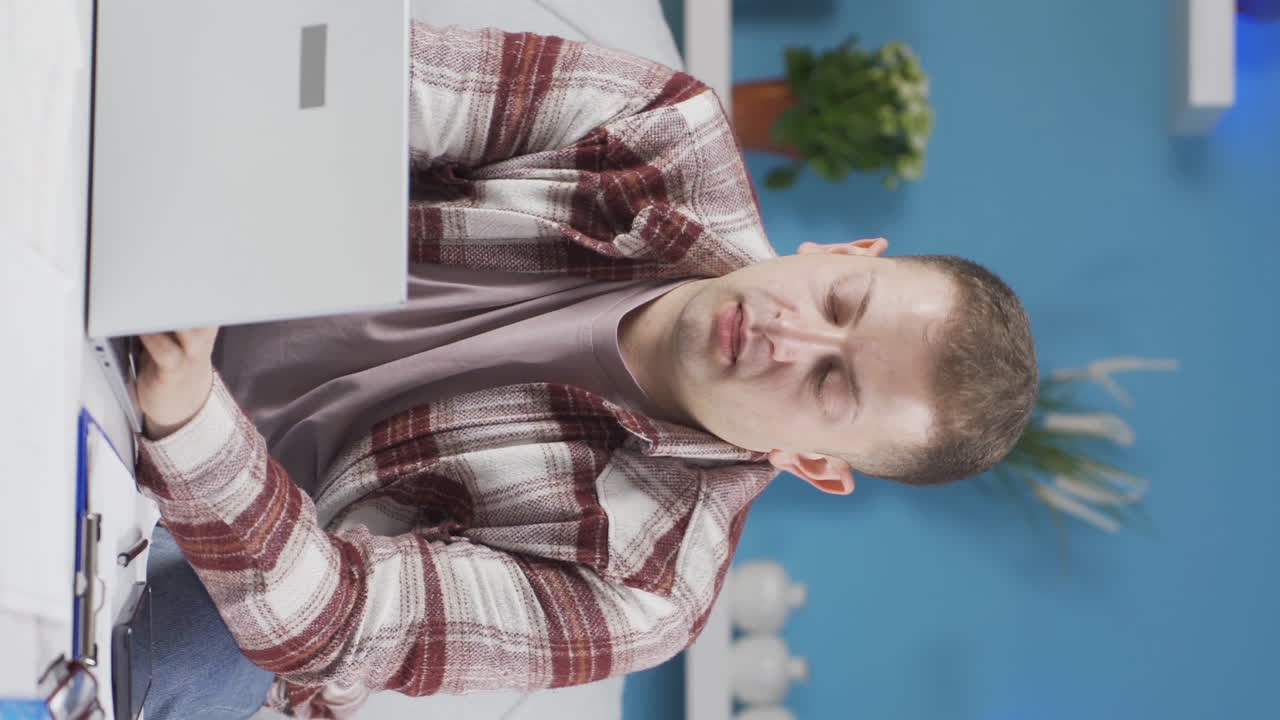 video vertical de un trabajador de oficina en casa el hombre tiene fatiga.