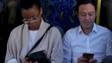 Commuters-using-mobile-phone-and-digital-tablet-while-travelling-in-bus-4k