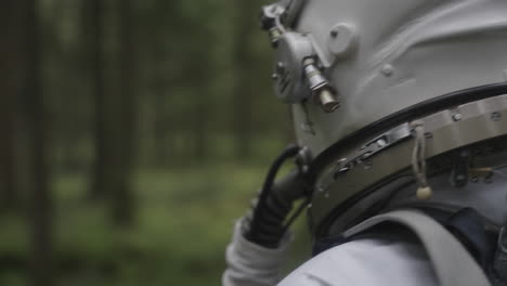 astronaut in space suit walking trough forest