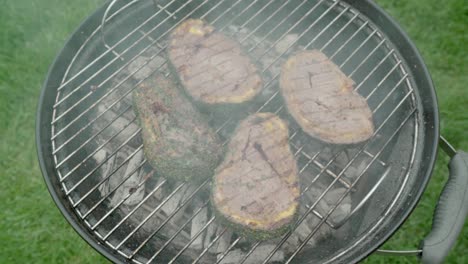 Steak-covered-with-minced-meat-and-cheddar-cheese-is-being-cooked-on-a-grill