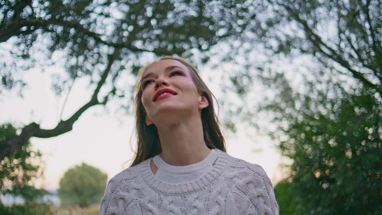 Happy girl looking greenery garden trees closeup. Woman contemplating green park