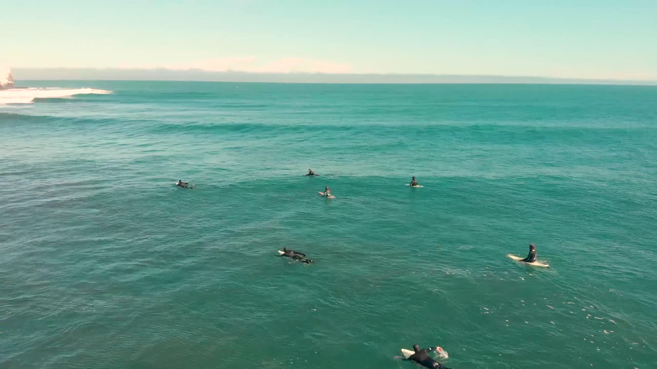Group of surfers waiting and paddling for a wave on a clear morning in the Pacific ocean, Pichilemu, Chile-4K