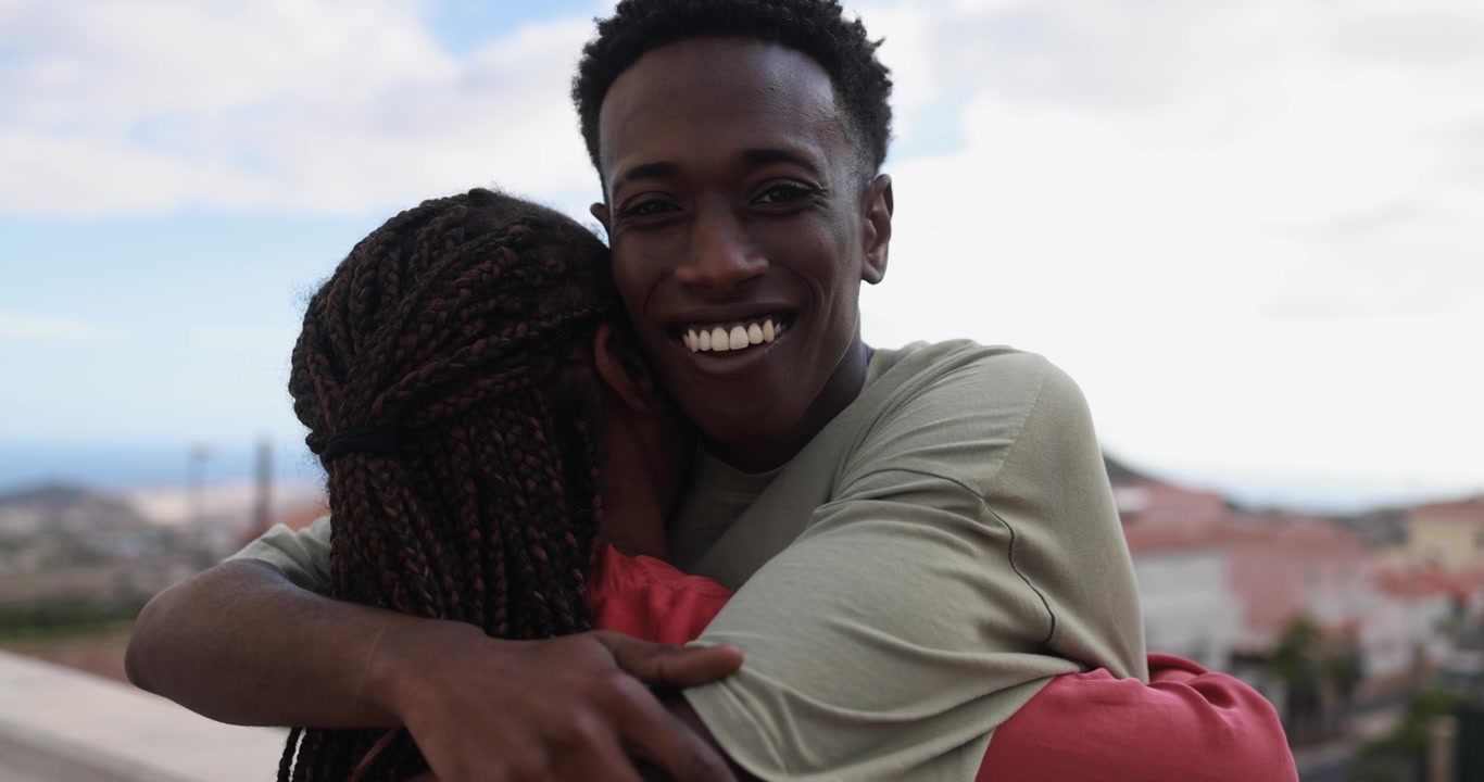 Happy African American Man Smiling While Embracing Woman Outdoors
