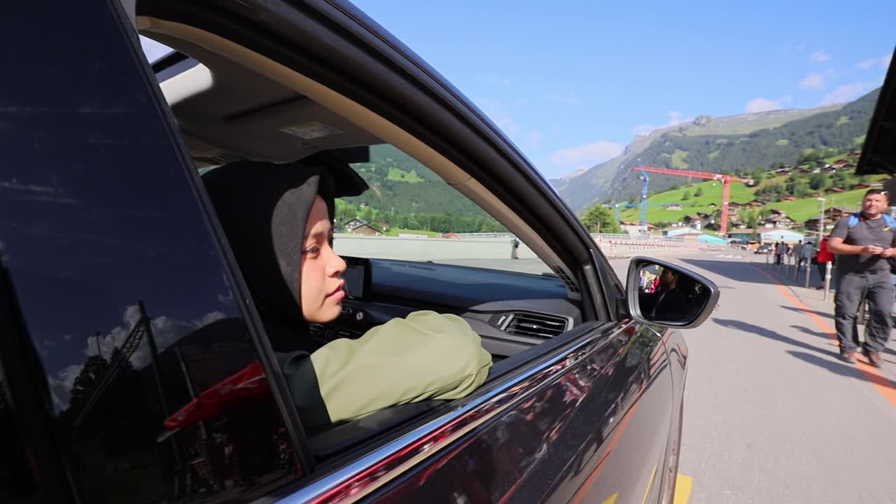 mujer hijab mirando por la ventana del auto por la mañana en suiza