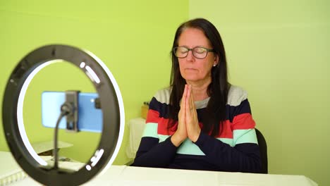 Mujer-Madura-Meditando-Sentada-Frente-A-Un-Teléfono-Inteligente---Plano-Medio