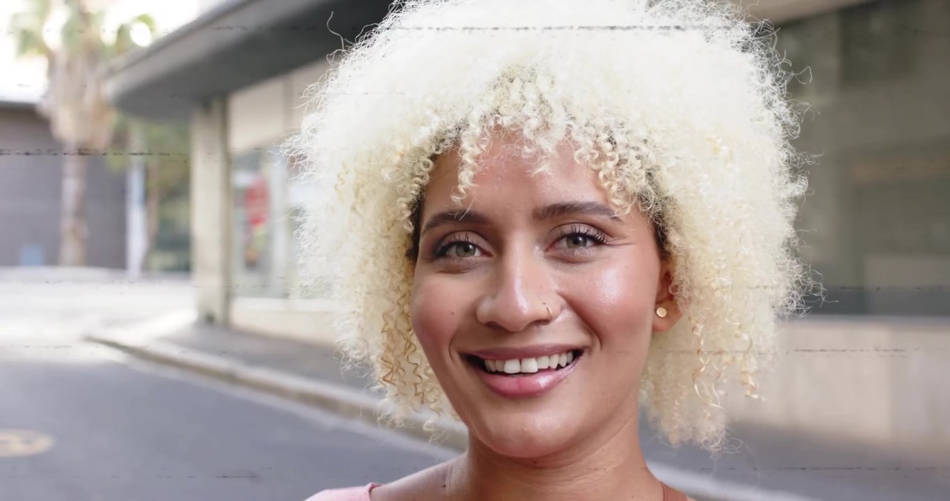 Linhas de falha (glitch) desaparecendo em uma rua urbana, revelando uma mulher sorrindo em uma introdução com tema de tecnologia