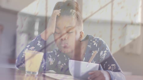 Animation-of-shadow-of-window-and-rain-over-african-american-girl-asleep-at-breakfast-table