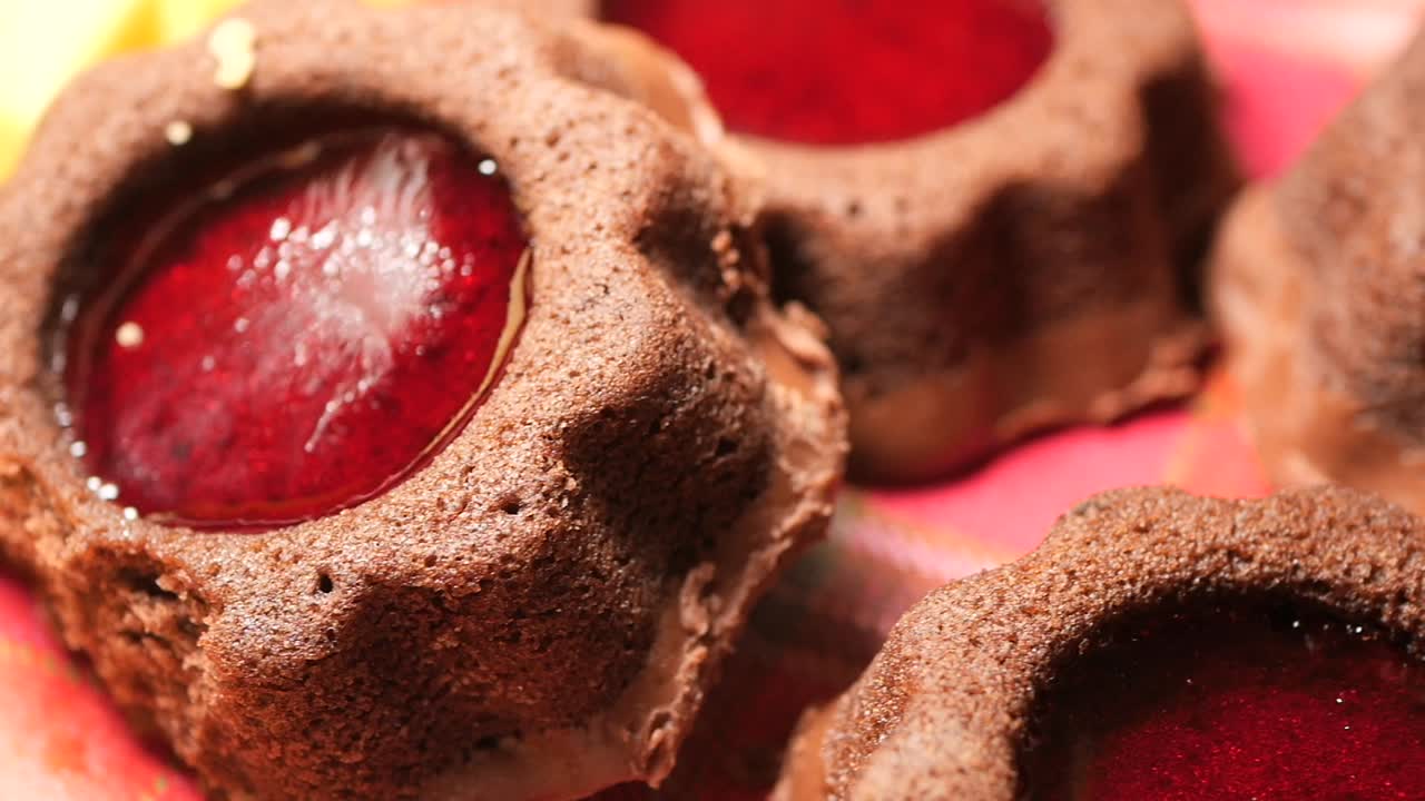 Close-up of chocolate cookies with red jelly centers