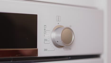 woman's hand tuning on the control knob of electric stove