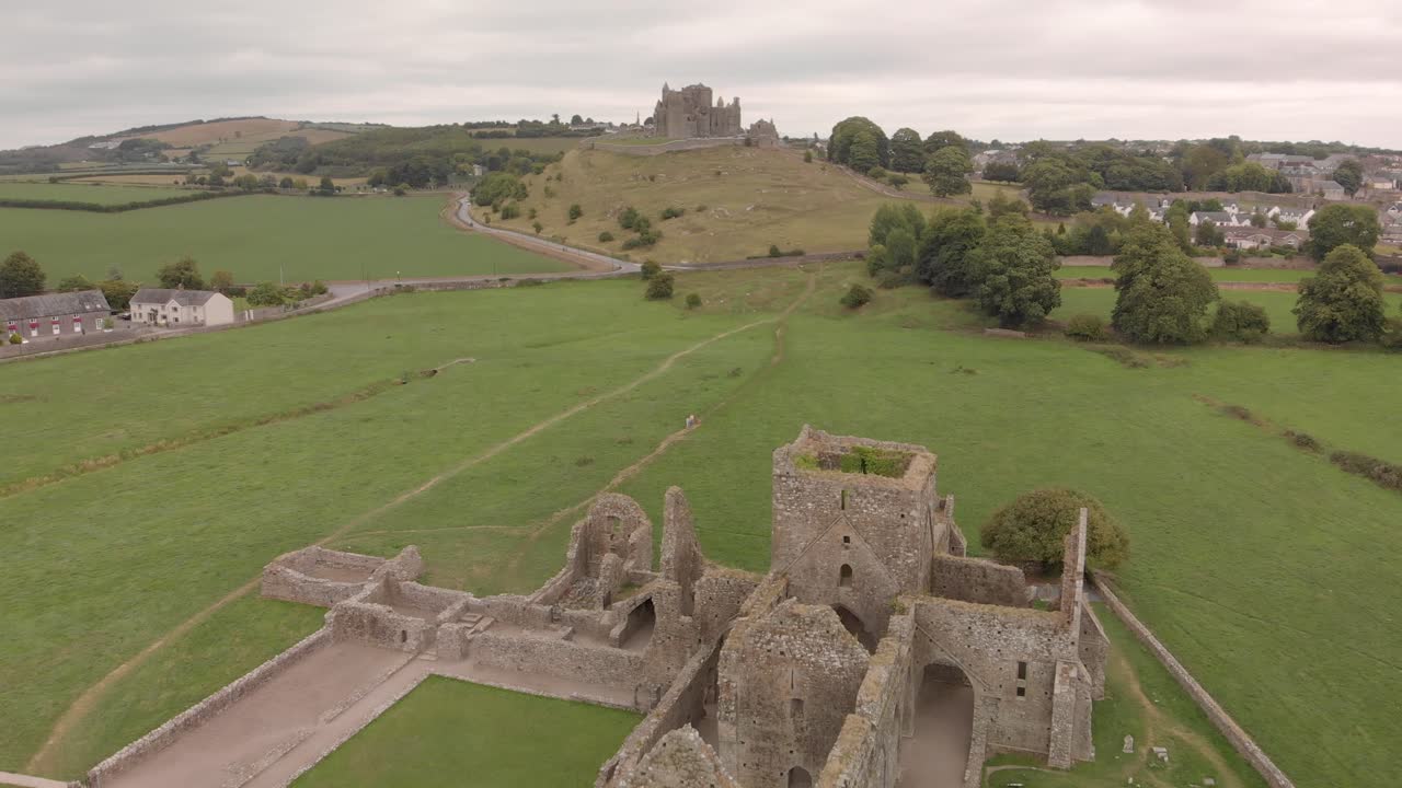sobrevuelo aéreo de las ruinas de la abadía del siglo xiii con senderos que conducen a la histórica "roca de cashel" en el fondo, tipperary irlanda