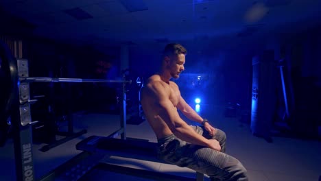 strong male naked torso. attractive tall muscular bodybuilder doing heavy exercise in moder fitness center