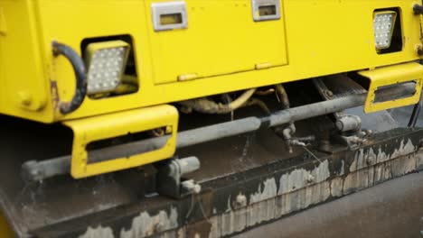 process of asphalting road construction infrastructure by compressing, compacting, leveling and smoothing the asphalt road surface using a tandem roller