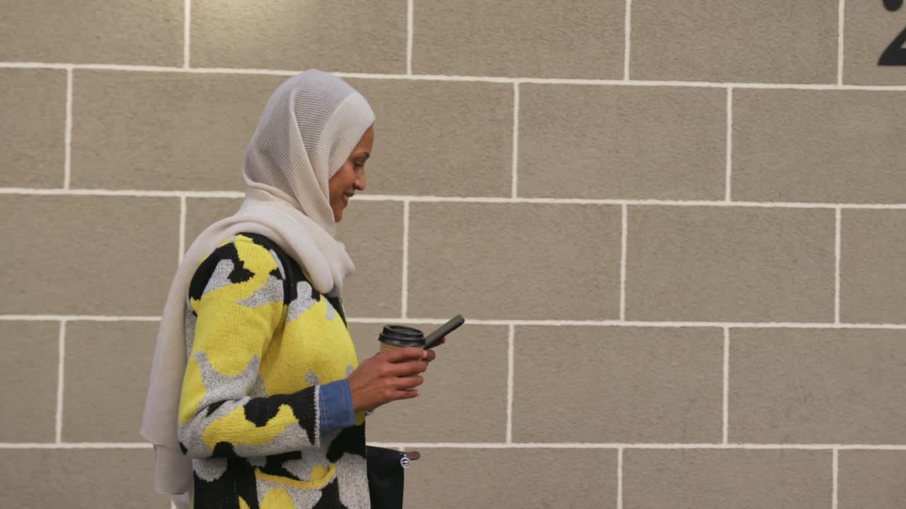 히자브를 입은 젊은 여성이 도시를 돌아다니고 있습니다.