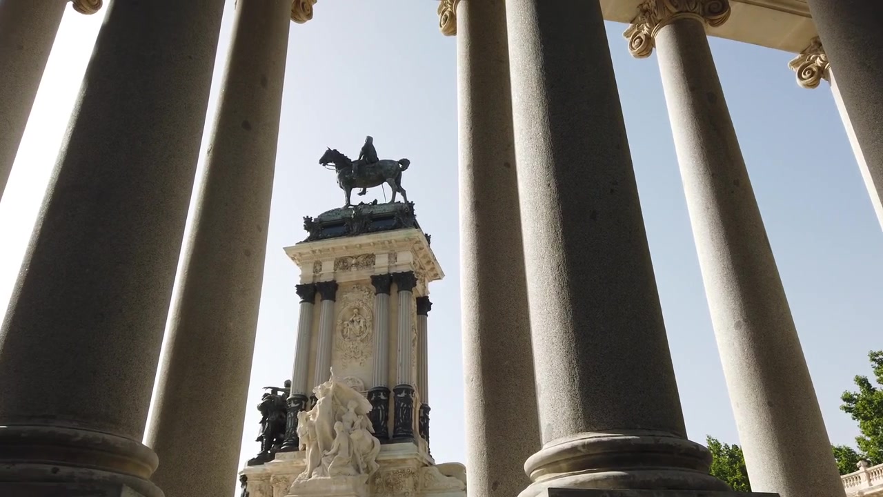 Panoramica dal basso delle colonne del Monumento ad Alfonso XII nel Parco del Retiro, Madrid, Spagna, e della statua equestre