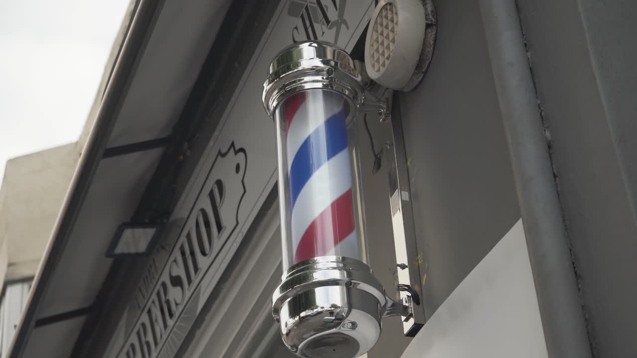 Outside spining signal indicator of a traditional male barber shop in brighton, england uk. place for nice hair cut