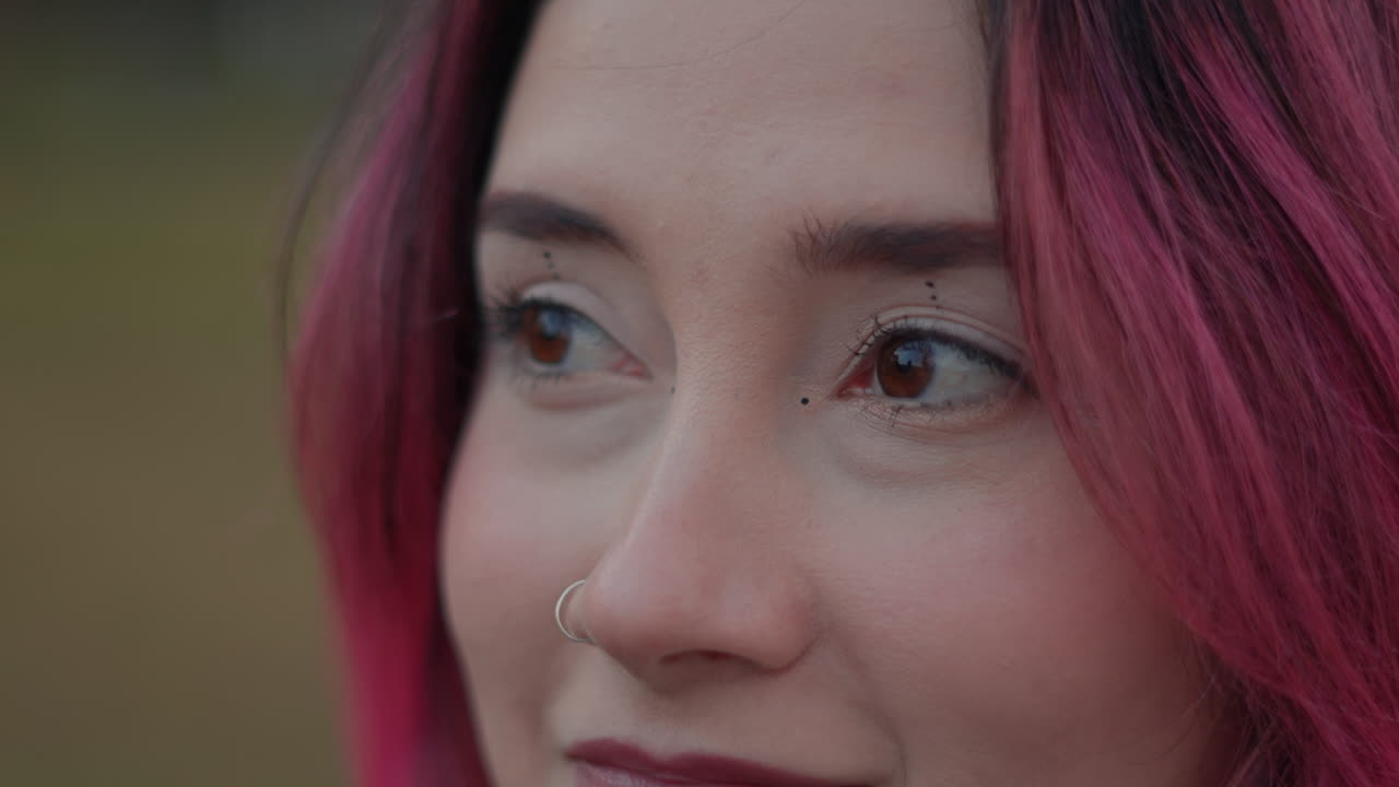 Close-up portrait of a young woman with pink hair