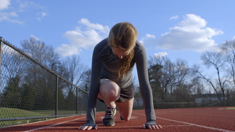 teen athlete in ready position for her run at the track