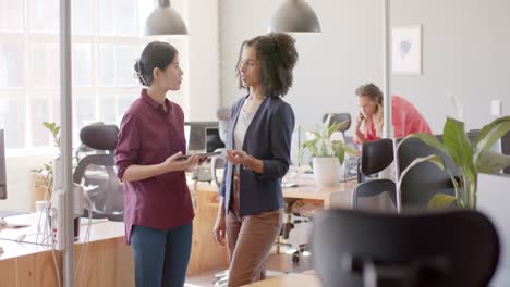 Happy-diverse-casual-businesswomen-talking-standing-in-office,-slow-motion