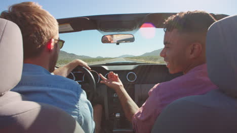 two men in convertible car driving along road shot on r3d