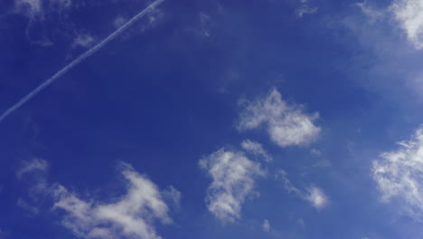 blue sky with fast moving clouds and some airplanes