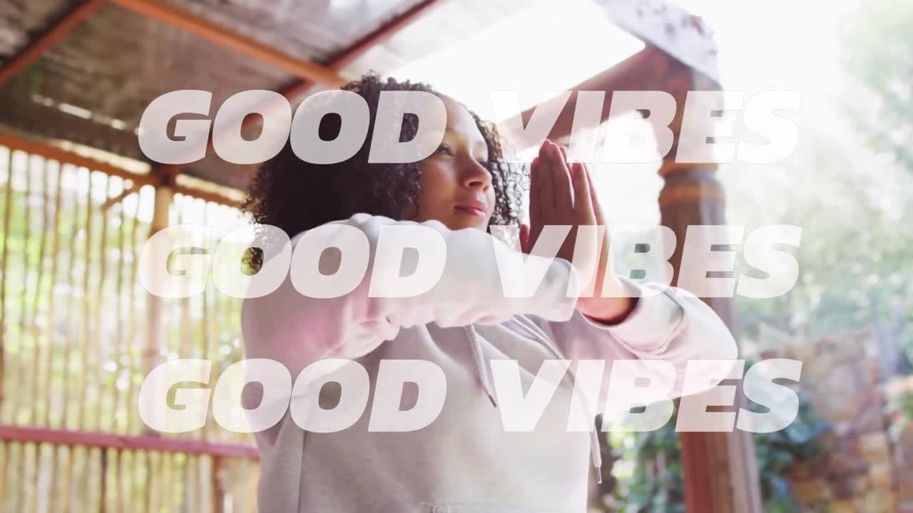 Animation of good vibes text over african american woman practicing yoga