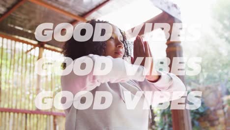 animation of good vibes text over african american woman practicing yoga