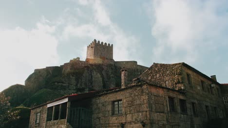 torre medieval de la casa de piedra y de la fortaleza bajo el cielo tenue y la bengala del sol