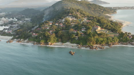 vista aérea de drones de una costa rocosa paradisíaca puesta de sol, jurere internacional, praia do forte, florianópolis, santa catarina, brasil