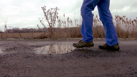 cerca de un charco en el que un hombre entra mientras camina - cámara lenta