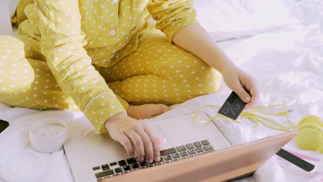 mujer en pijama amarilla comprando en línea