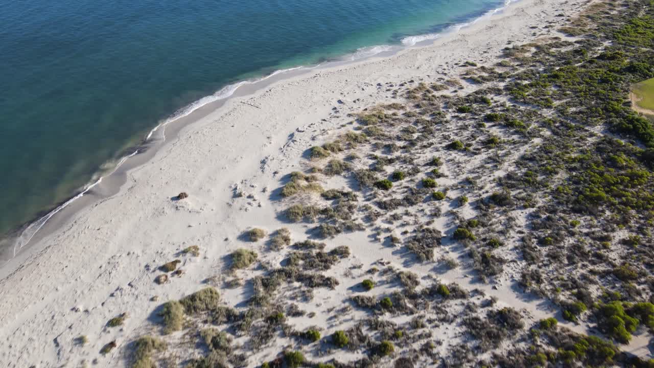 Drone aerial over greenery to a white sand beautiful beach of Jurien Bay