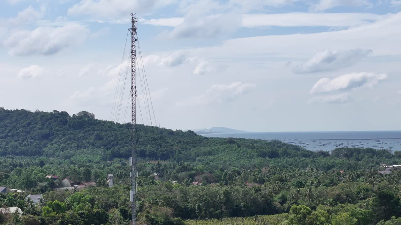 Drone footage presents a circling view of an antenna tower and featuring extensive greenery along its verges, with residents interspersed throughout, indicative of a thoughtfully planned community