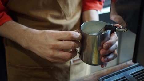 barista steaming milk for coffee