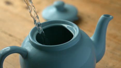 hot water pouring into blue teapot