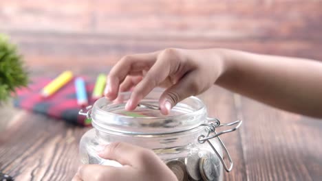 child saving money in a glass jar