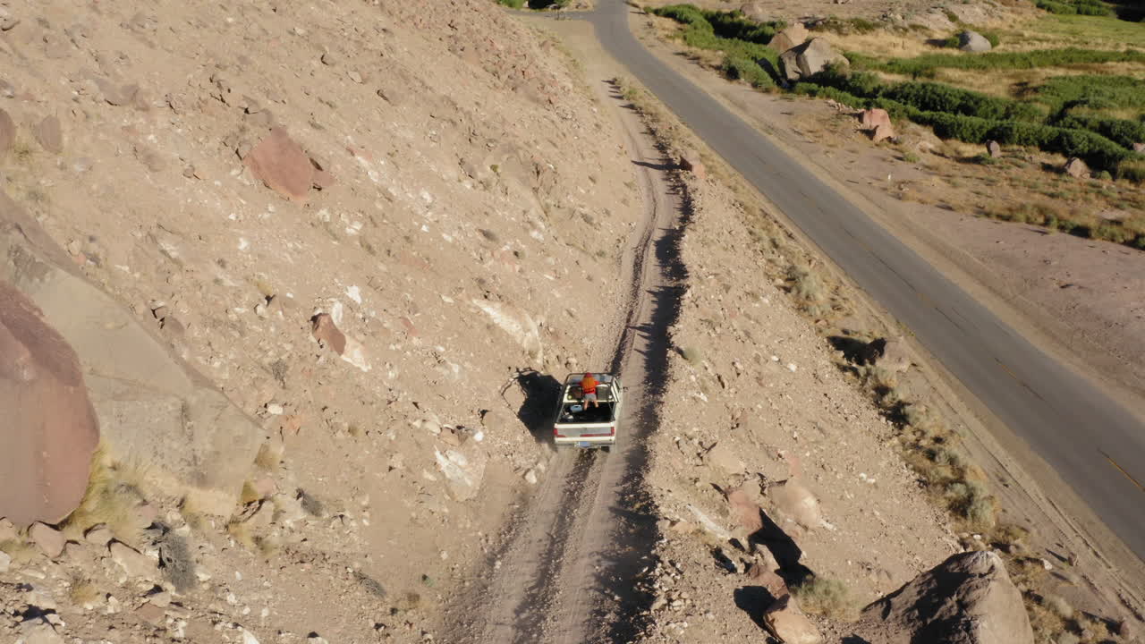 해가 지는 동안 산 정상을 따라 달리는 자동차들의 조감도