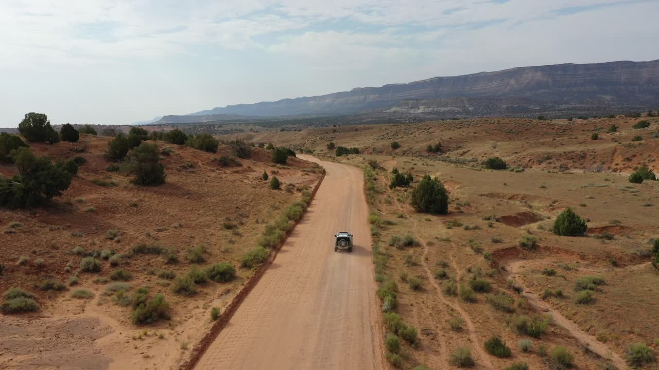 vehículo de cuatro por cuatro conduciendo a través de un camino polvoriento durante el día