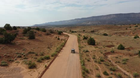 four by four vehicle driving through dusty road at daytime