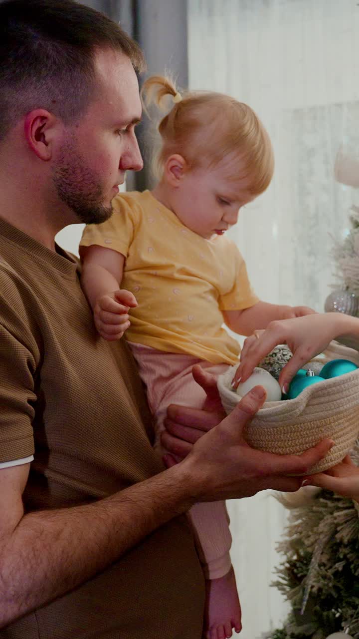 Un momento toccante tra padre e figlia, che condividono la gioia mentre decorano un albero di Natale splendidamente addobbato con ornamenti colorati, in un'atmosfera piena di allegria e unità