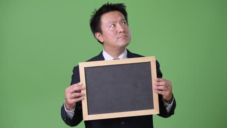 mature japanese businessman against green background