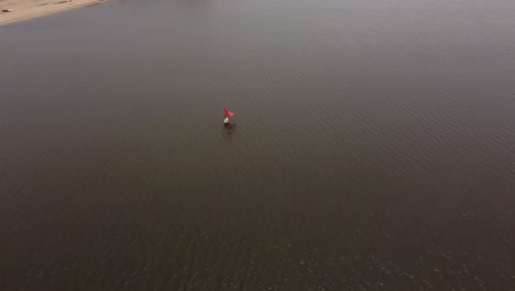 una persona practicando windsurf en las tranquilas aguas de laguna garzon