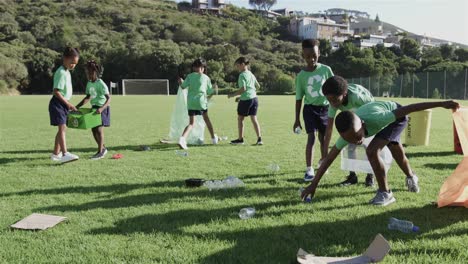 happy diverse schoolchildren wearing recycle tshirts cleaning sports field at elementary school