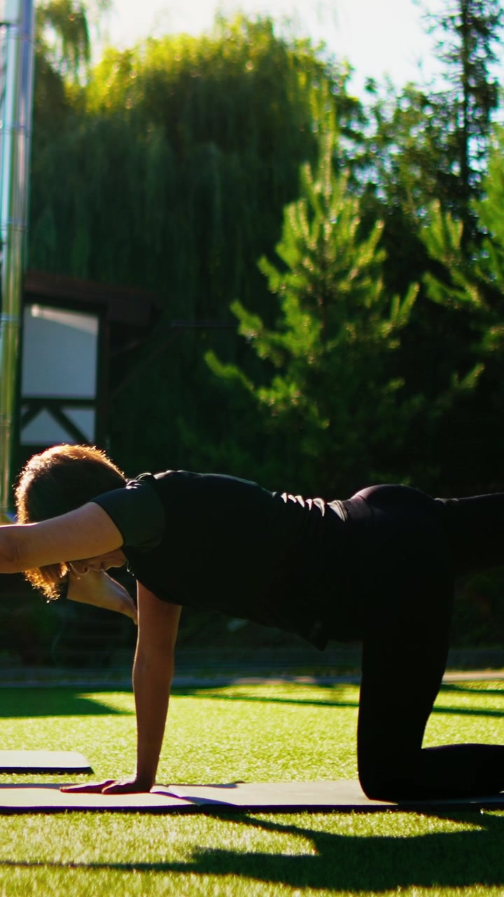 Woman Performing Bird-Dog Exercise on Yoga Mat Outdoors