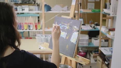 mujer pintando en un estudio de arte