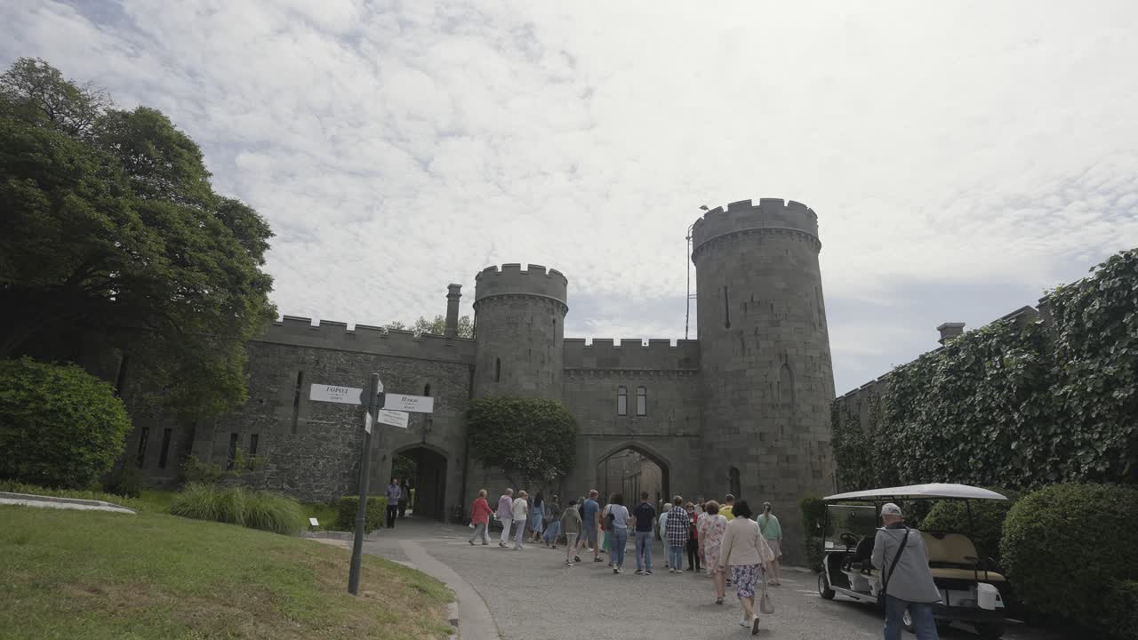 los visitantes entran por una entrada histórica del castillo.