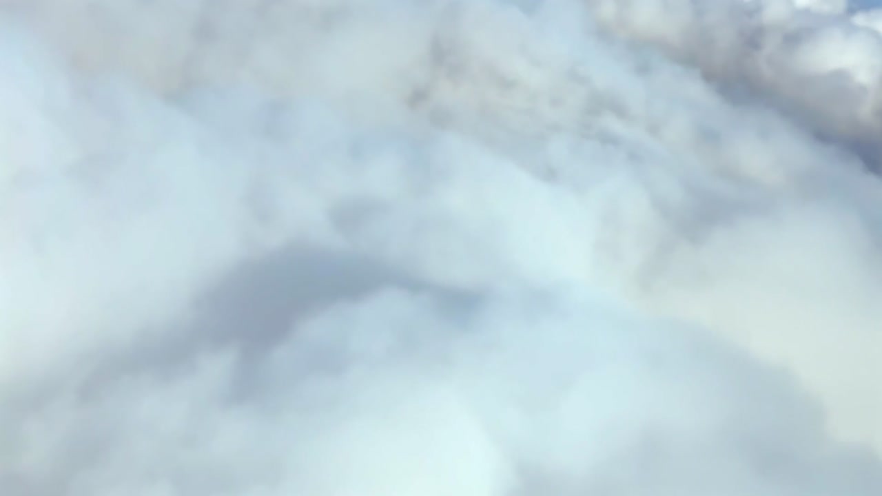 A left side view of the shadow of a jet airplane on the clouds, recorded from the cockpit