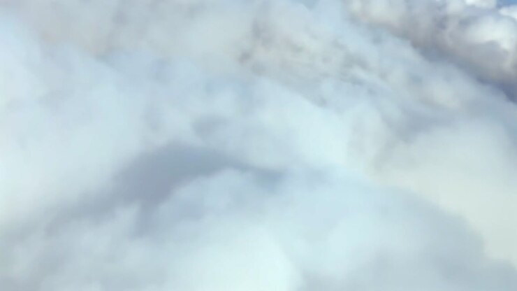 A left side view of the shadow of a jet airplane on the clouds, recorded from the cockpit