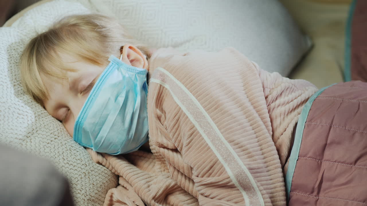 La mamma controlla la temperatura del suo bambino toccandogli la fronte.