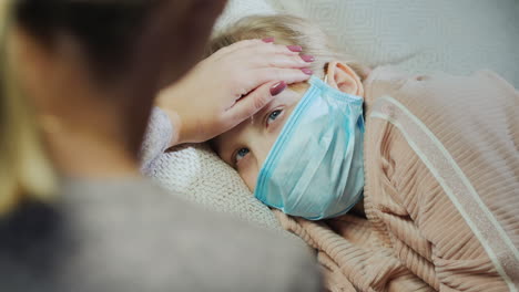 mom checks her baby's temperature touches her forehead